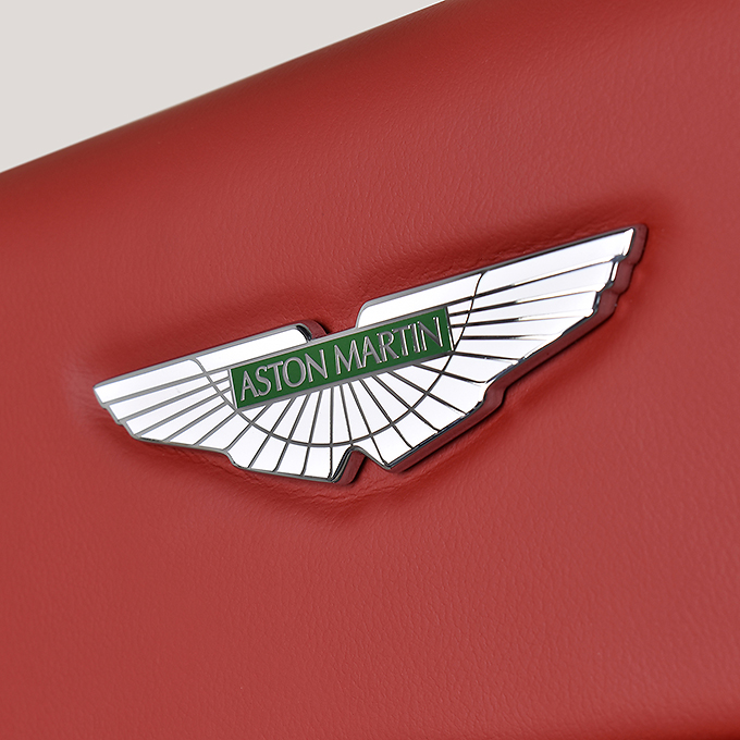 a close-up photograph of an Aston Martin logo on some luggage